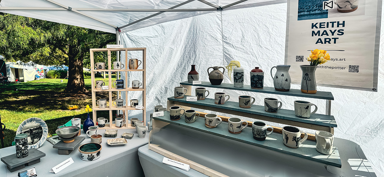 Keith Mays Art tent setup showing work with photography on ceramics