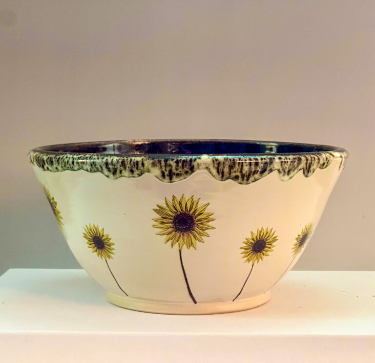 Bowl with green interior with images of sunflowers on the exterior.