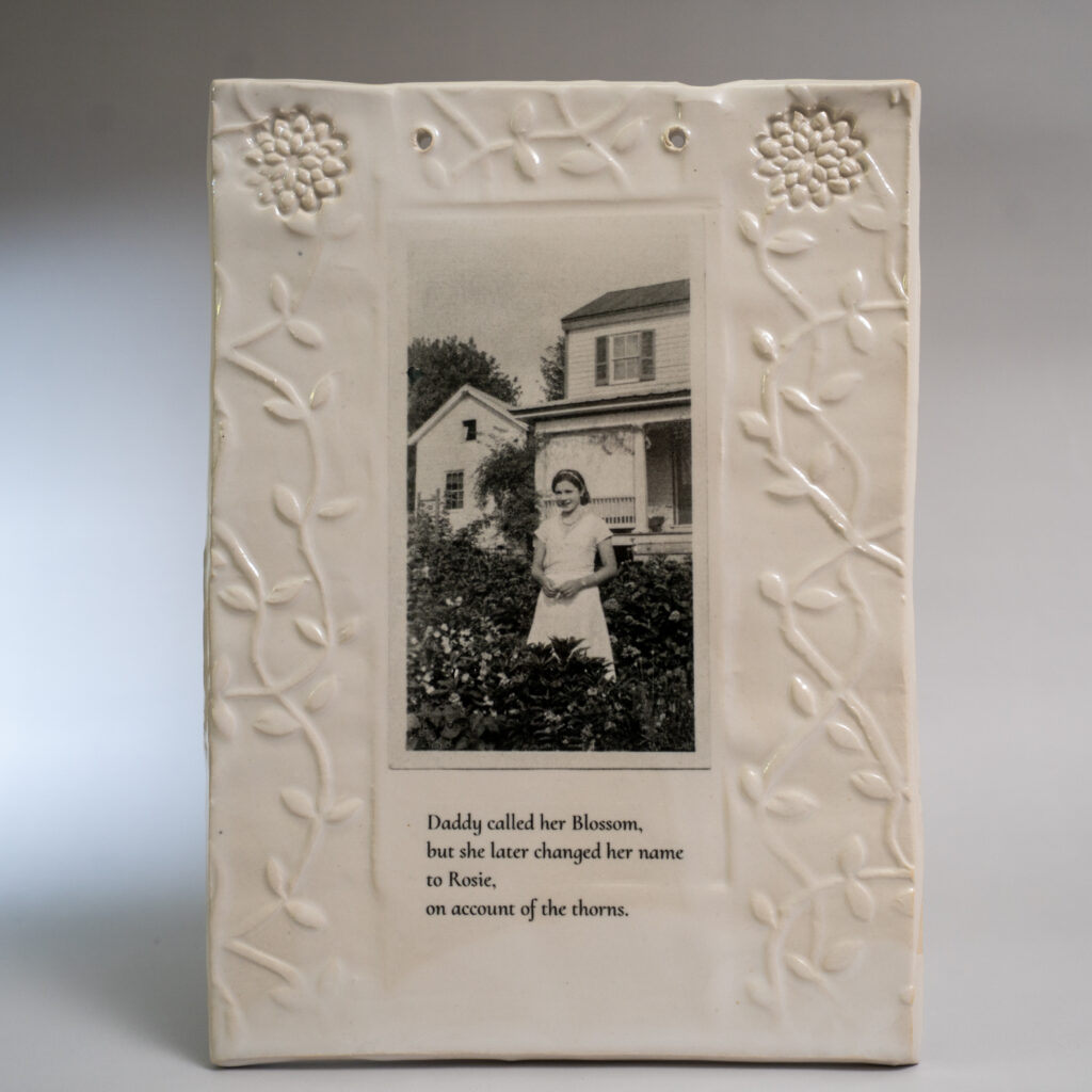 Ceramic frame with historic image of woman standing in garden.